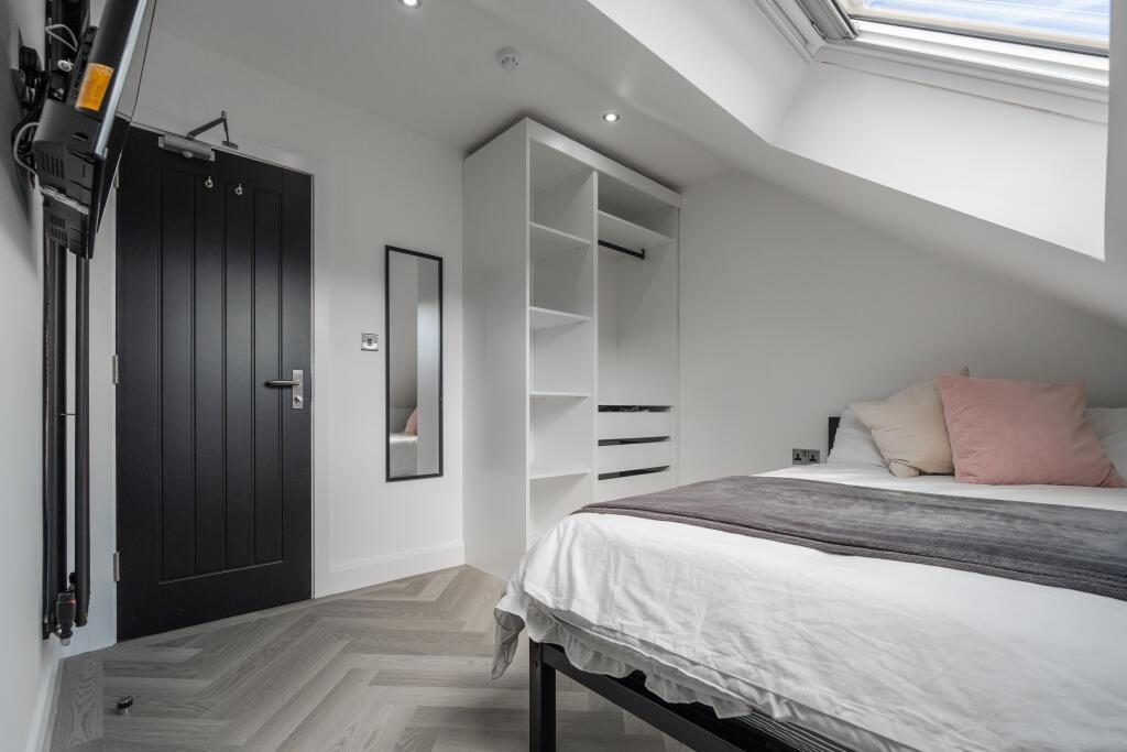 A bright and modern bedroom featuring a comfort...