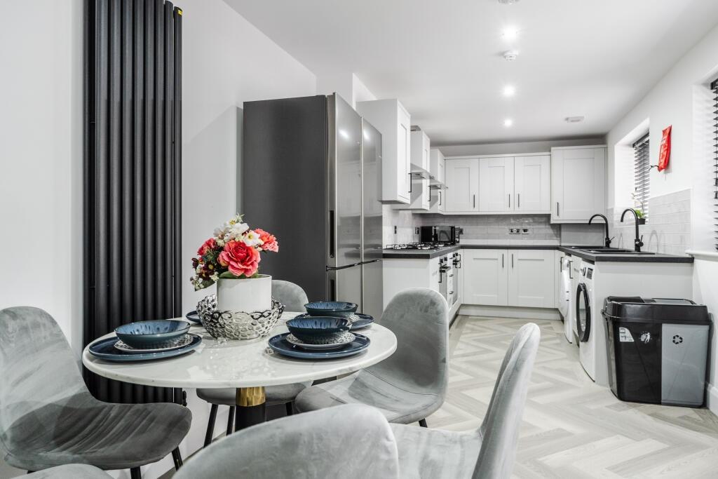 Modern and bright kitchen with sleek white cabi...