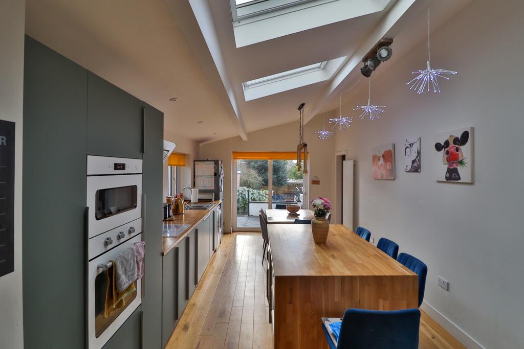 Extended Vaulted Island Kitchen matt green cupboar