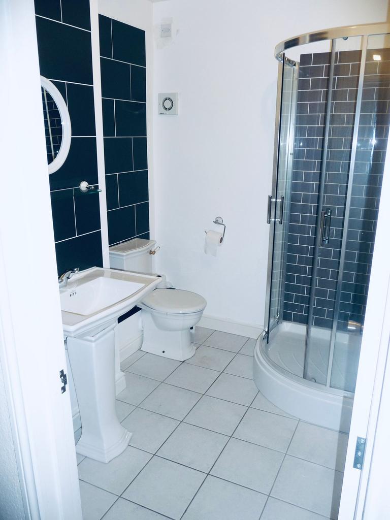 Bright, modern bathroom with a corner glass sho...