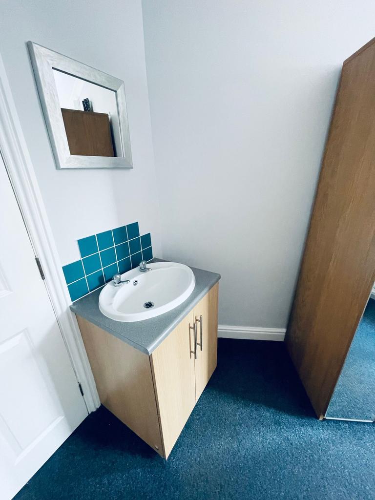 Compact ensuite-style corner sink with a neat v...