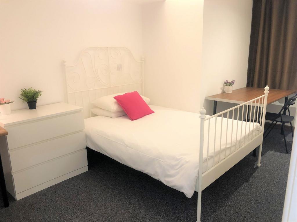 A neat and bright single bedroom featuring a wh...