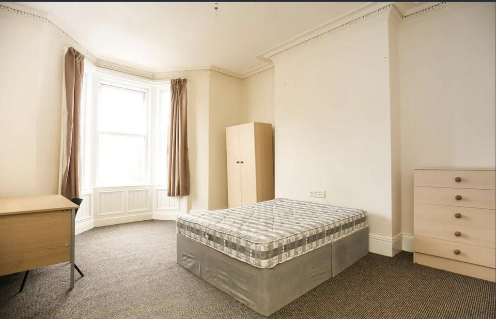 Bright, airy bedroom with a large bay window, n...