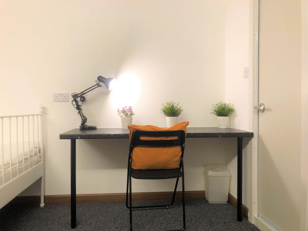 A simple, clean study area with a black desk an...