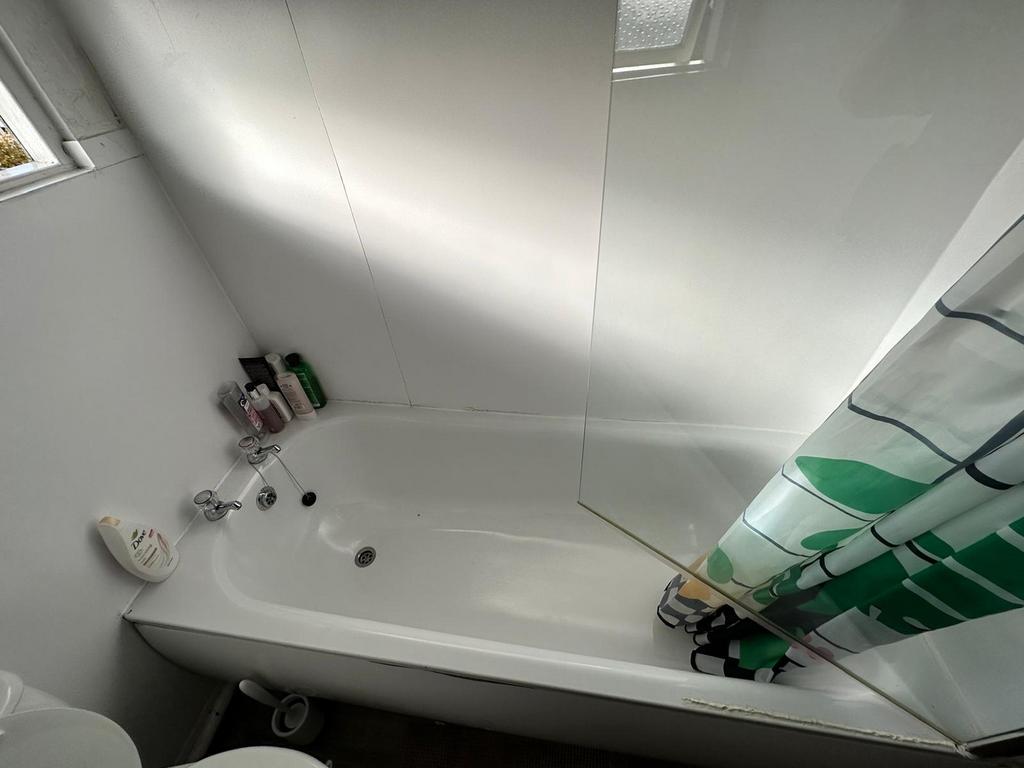 A bright and tidy bathroom featuring a bathtub ...