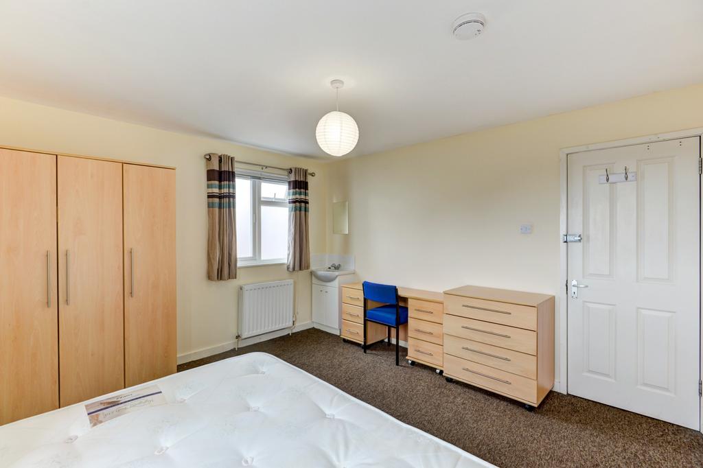 Bright, neatly presented bedroom featuring a do...