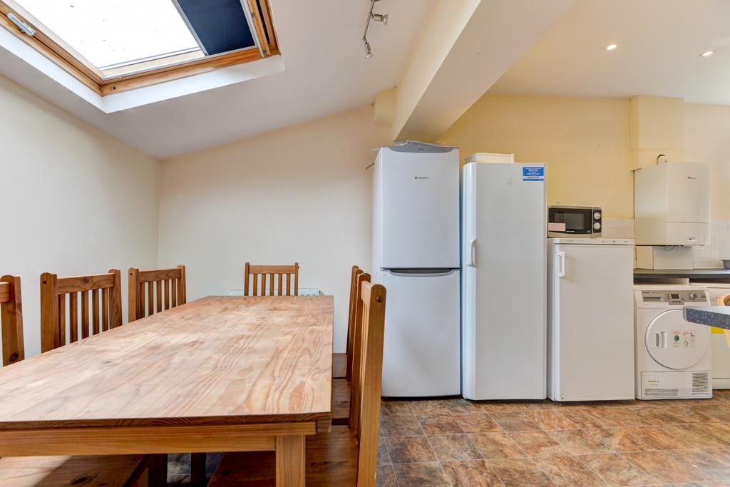 Bright open-plan kitchen with a wooden dining t...