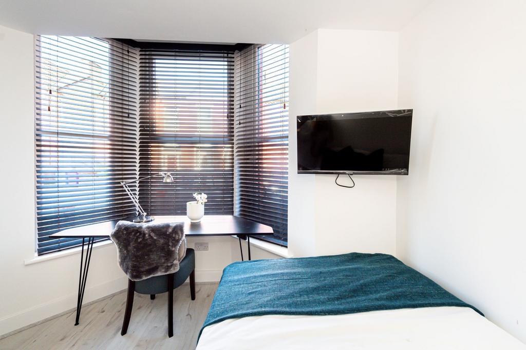 Modern bedroom with large window blinds, a comf...