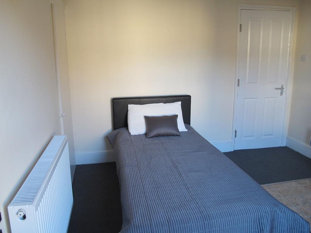 Neat single bedroom with a simple upholstered h...