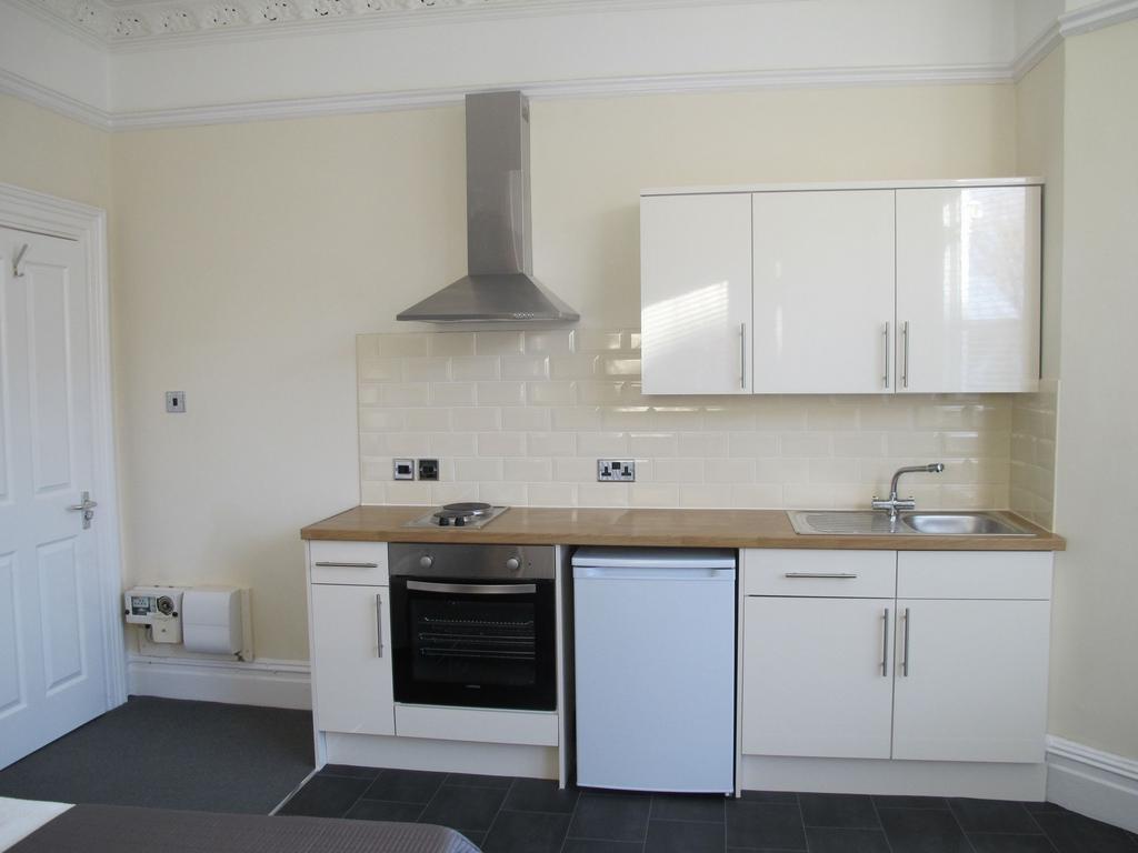 Bright, modern fitted kitchenette with white gl...