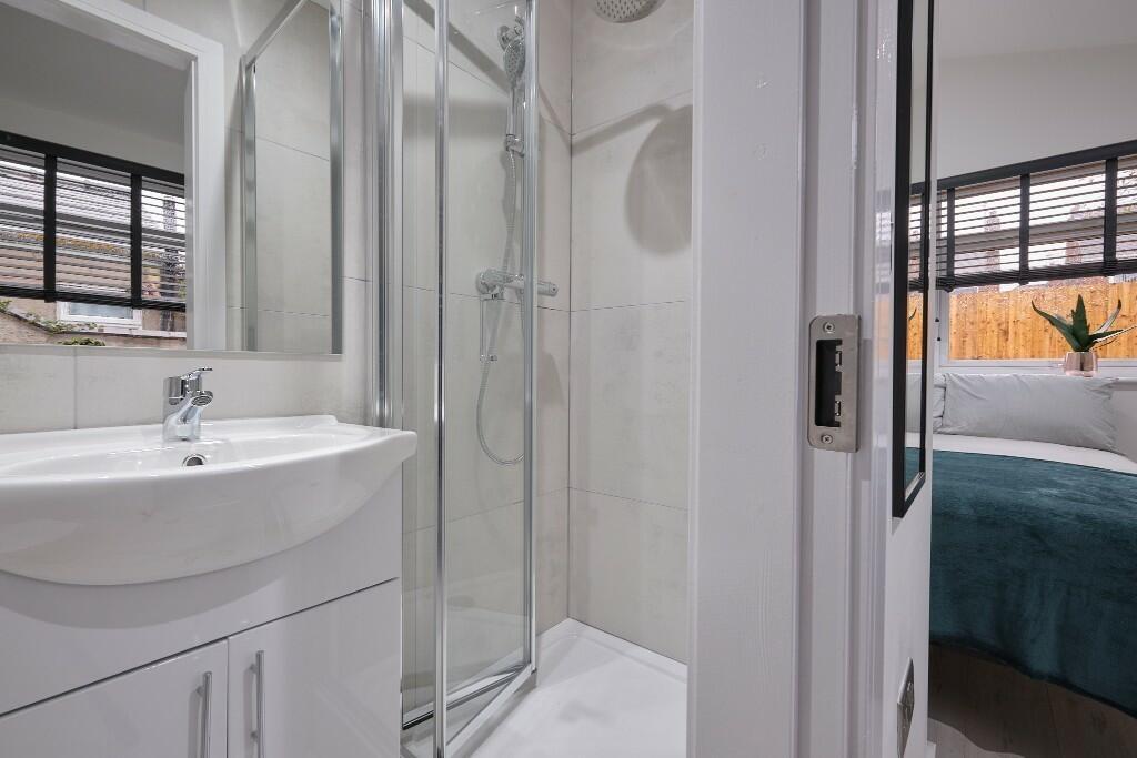 Bright modern bathroom with a curved-glass show...