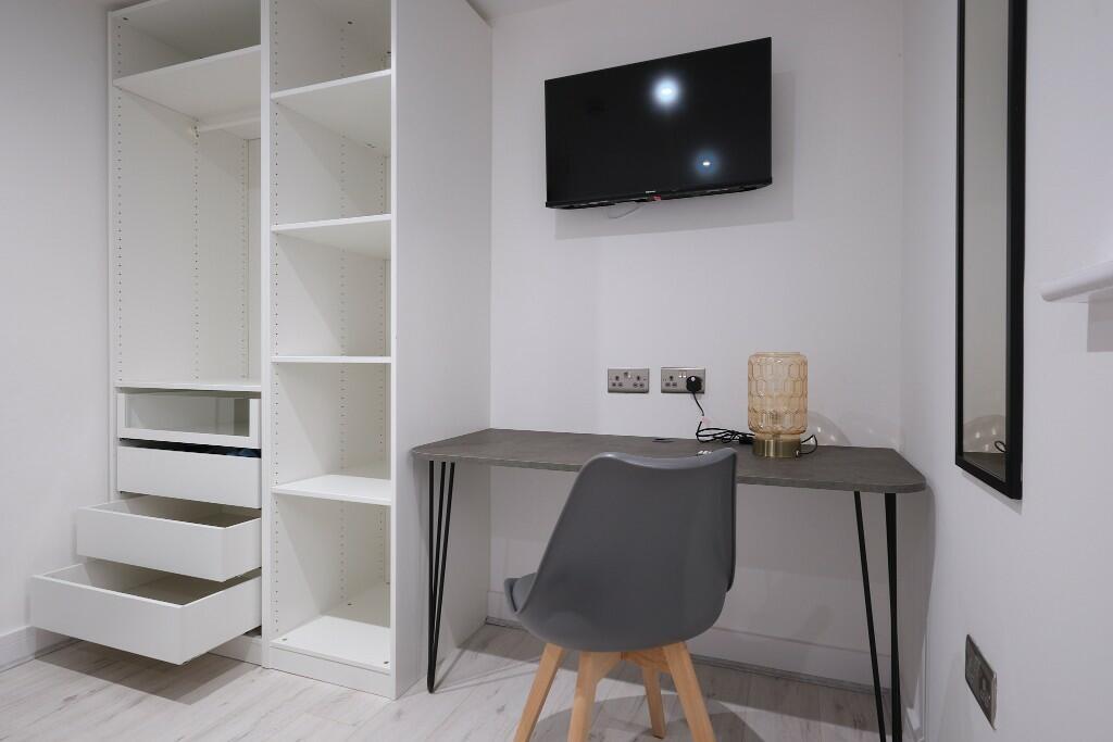 Bright, tidy bedroom corner with a sleek desk a...