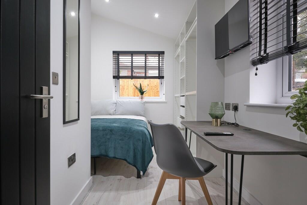 Bright, neatly styled single bedroom with a com...