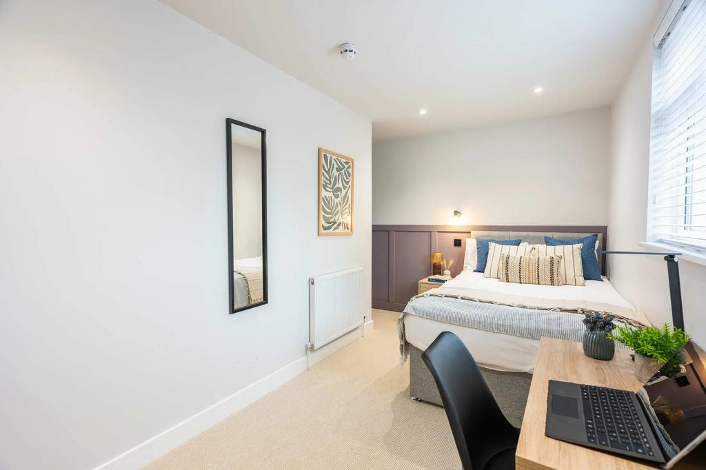 Modern and bright bedroom featuring a comfortab...