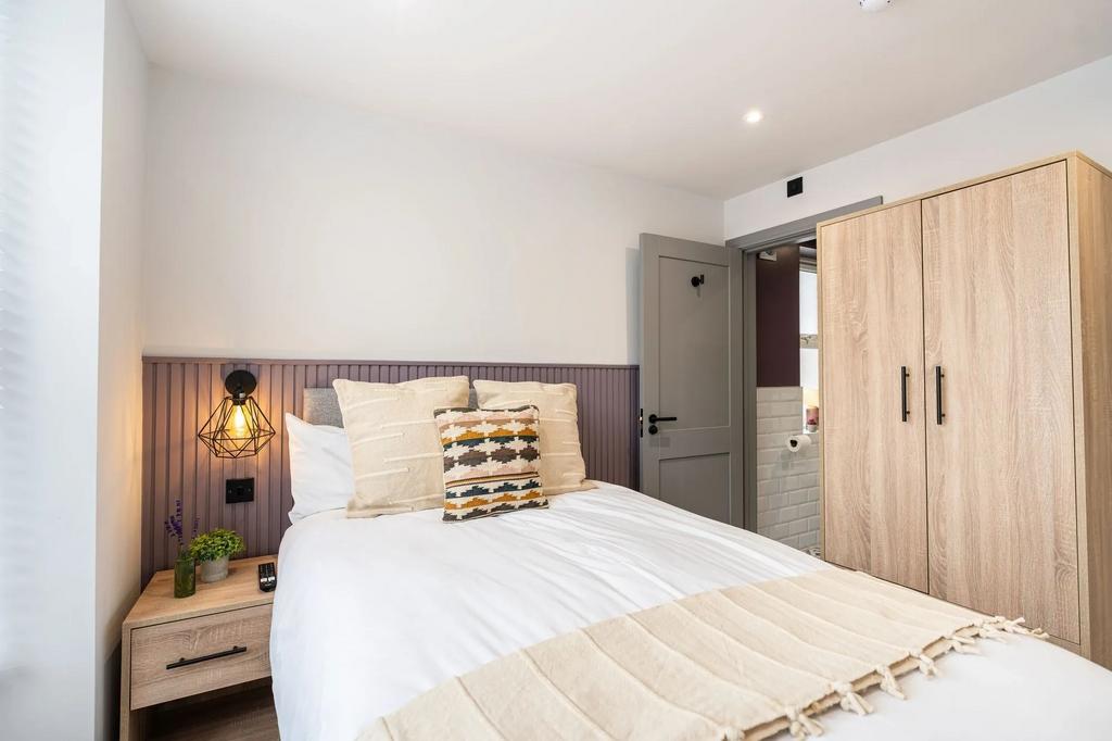 A spacious and well-lit master bedroom featurin...