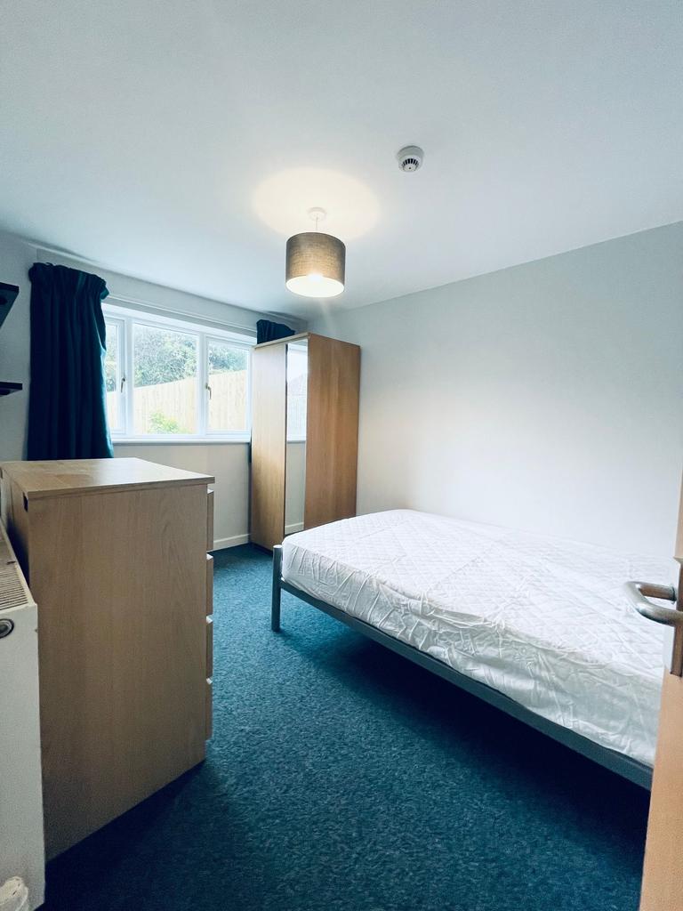 Bright, simply furnished bedroom with a double ...