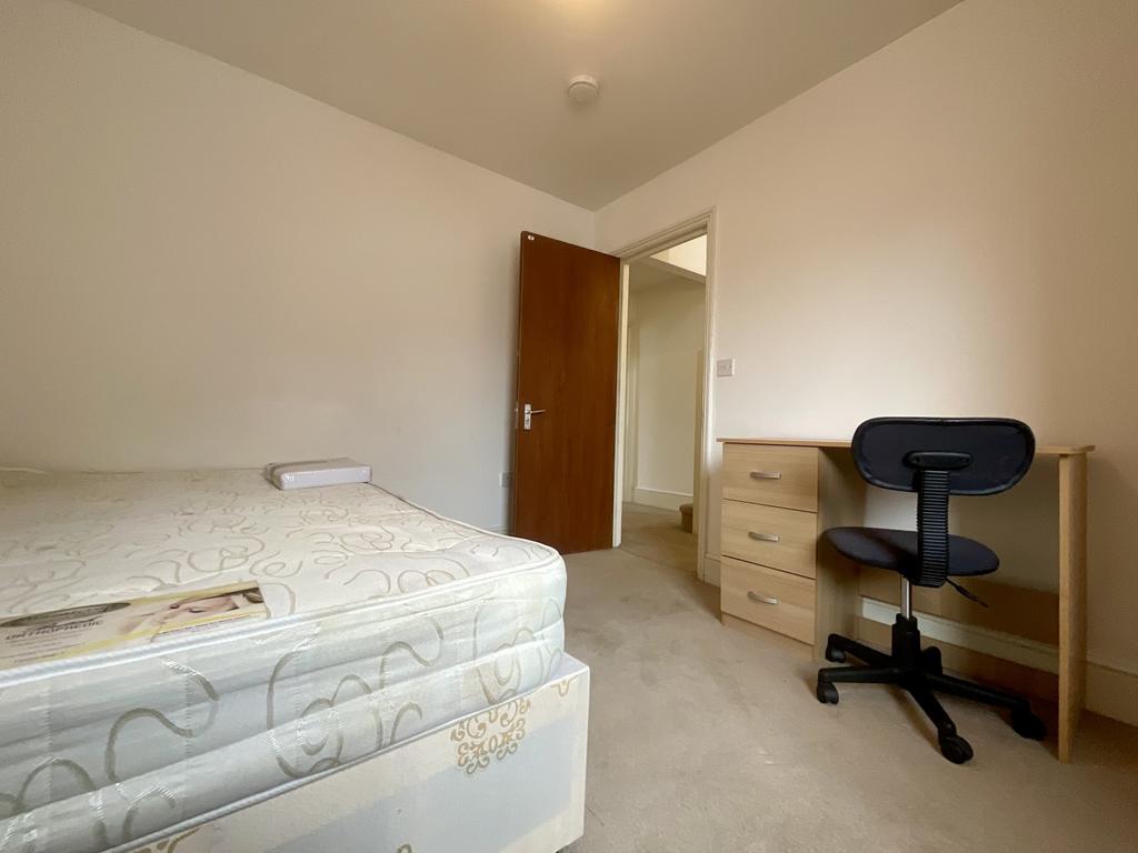Bright, simply furnished bedroom with a comfort...