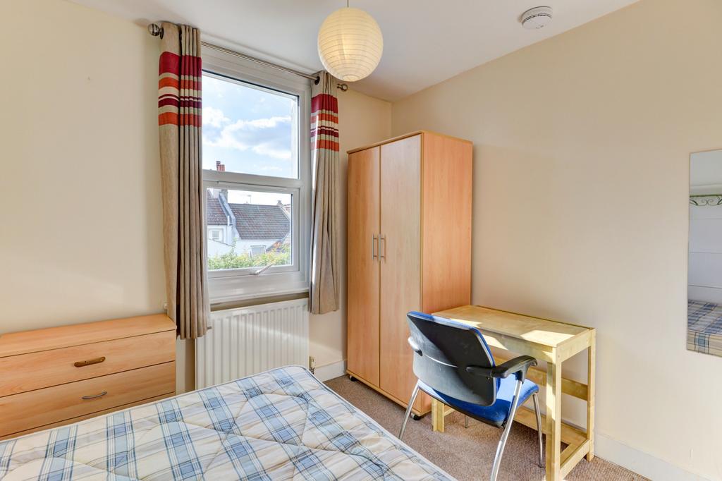 A bright and tidy student bedroom featuring a s...