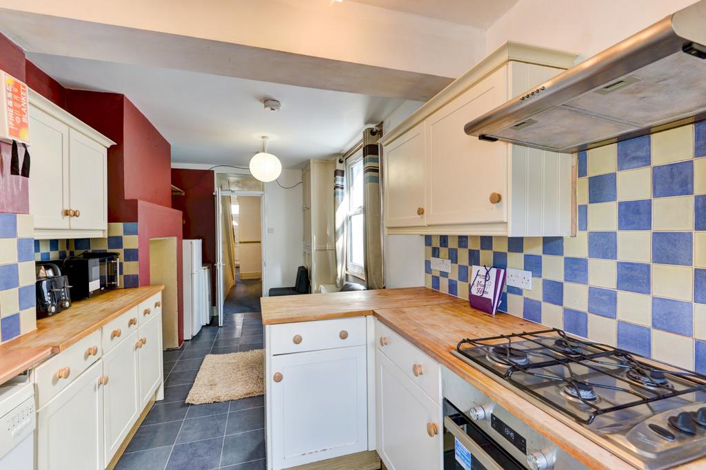 Bright galley-style kitchen with wooden counter...