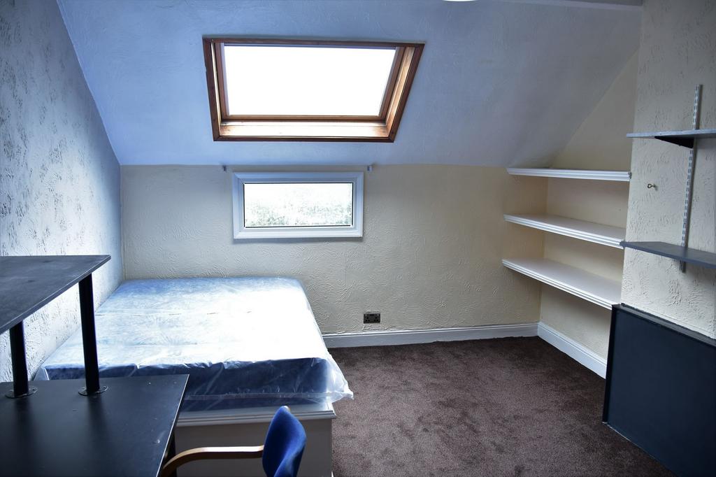 A cozy bedroom with a sloped ceiling featuring ...