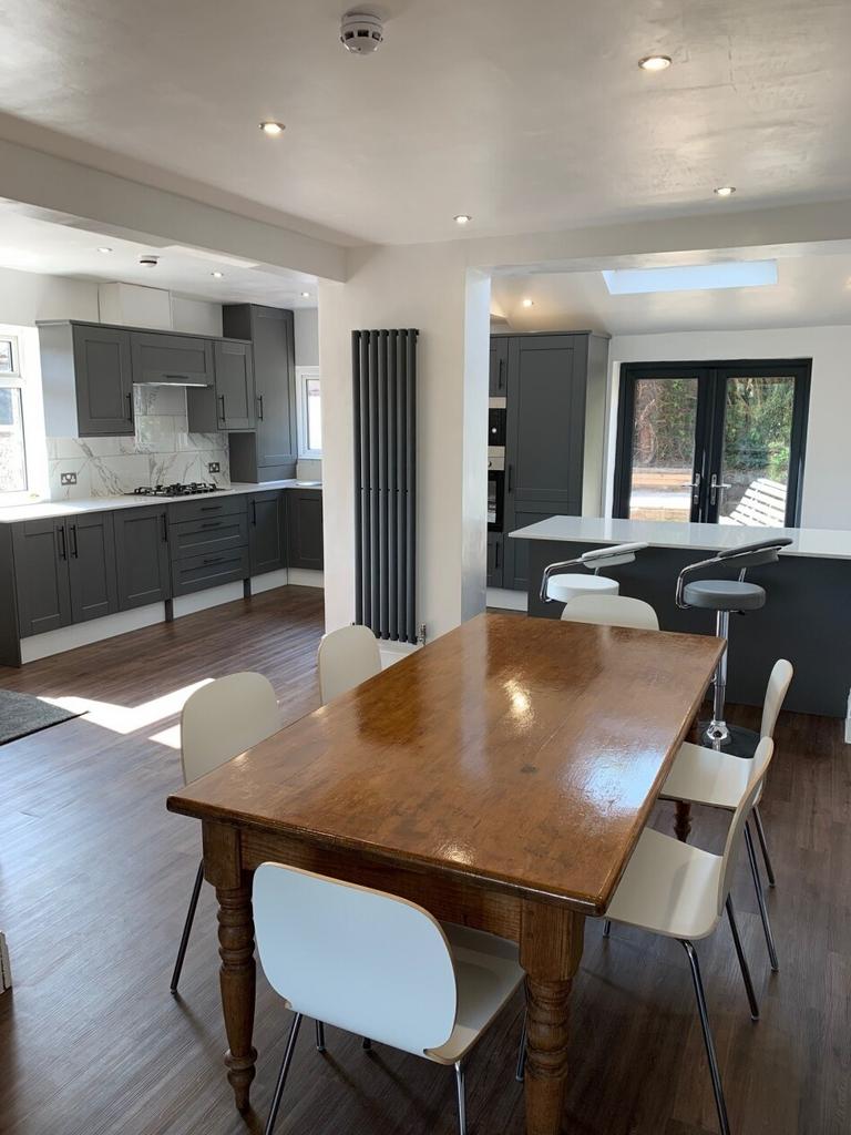 A bright and modern kitchen area with sleek gre...
