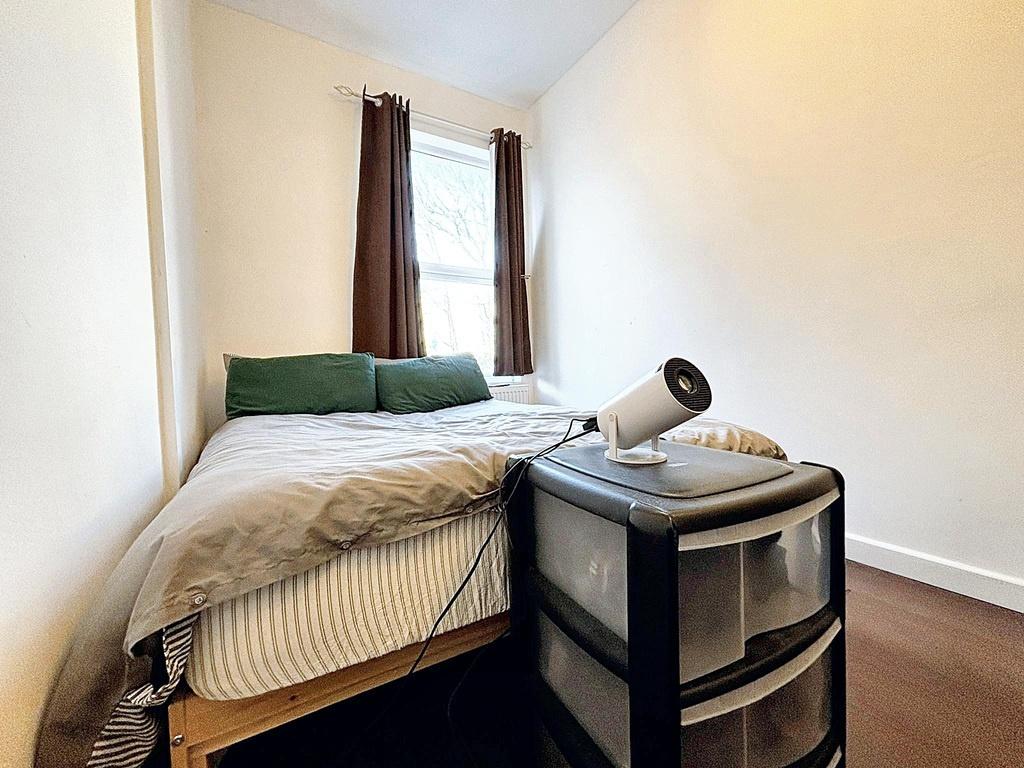 Bright, simply furnished bedroom with a comfy s...