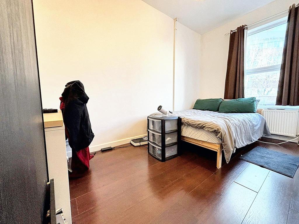 Bright, simply furnished bedroom with a double ...