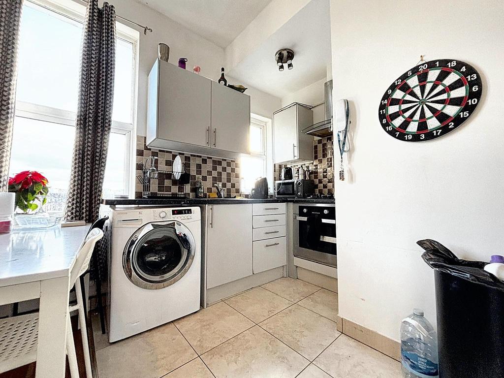 Bright modern kitchen with high cabinets, tiled...