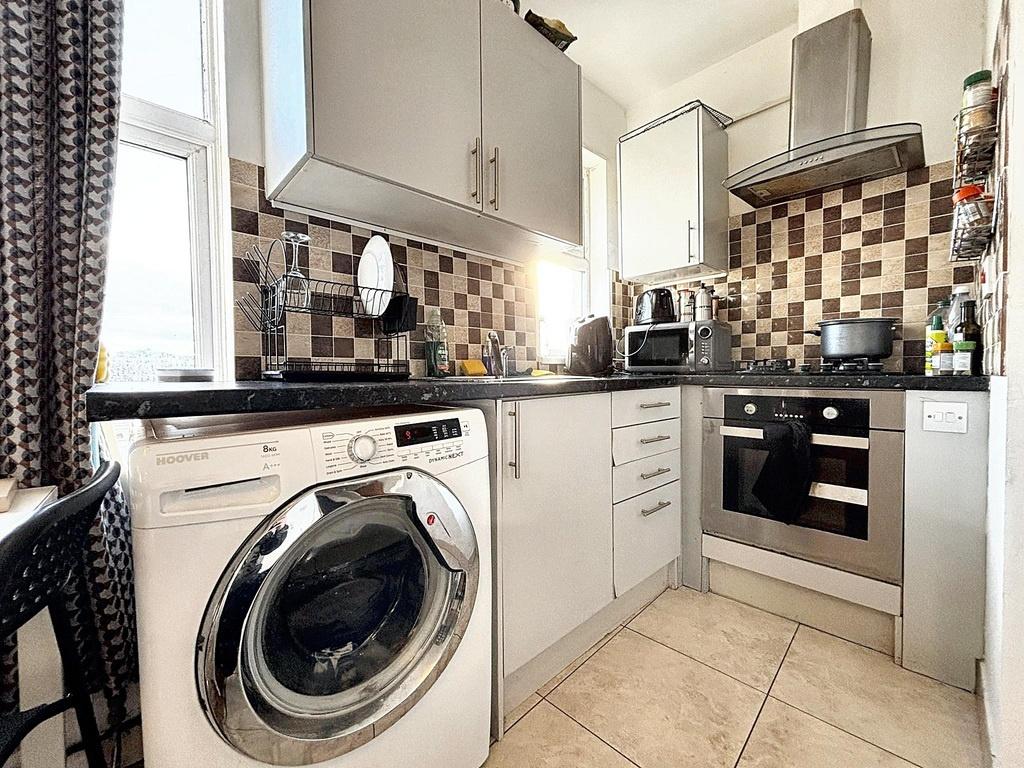 Bright, modern kitchen with tiled splashback, i...