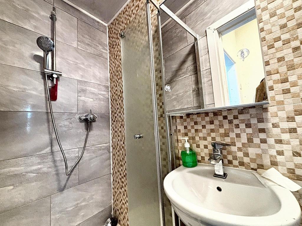 Modern bathroom with a glass-enclosed shower, c...