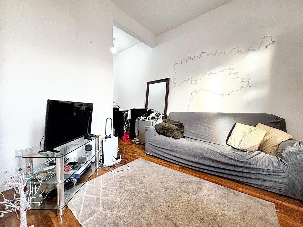Bright, simply furnished living room with a sof...