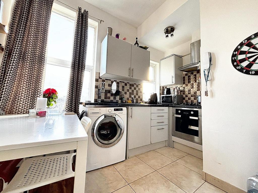 Bright compact kitchen with modern cabinetry, t...