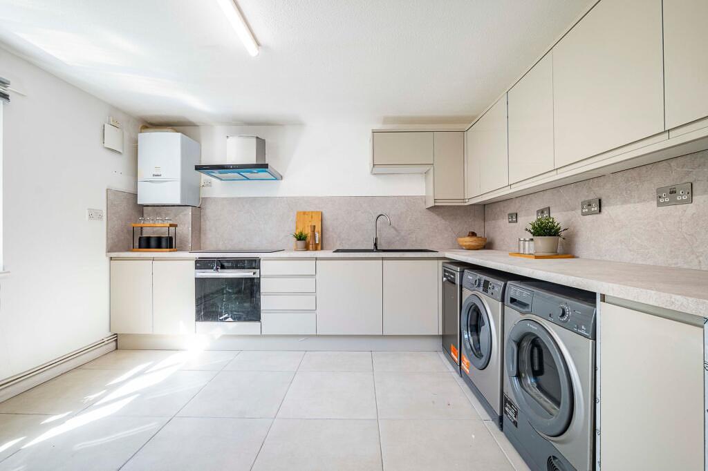 Bright modern kitchen with a long worktop, inte...