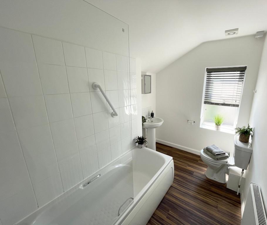 Bright, modern bathroom with a full bath and gl...