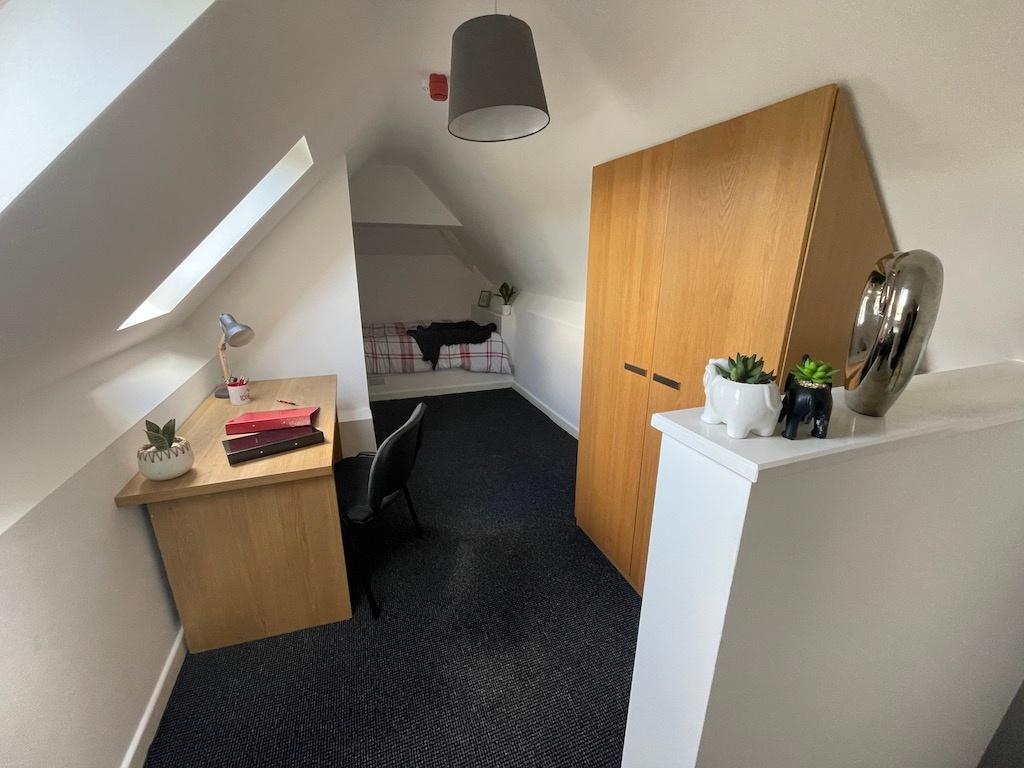 Bright attic single bedroom with a study desk b...