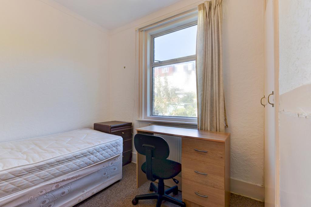 Bright, simply furnished bedroom with a single ...