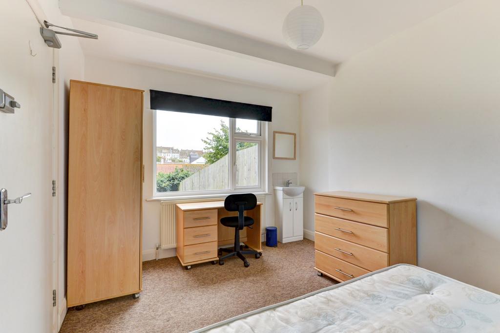 Bright, simply furnished bedroom with a large w...