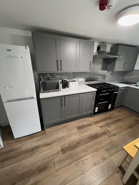 Modern fitted kitchen with grey cabinetry, free...