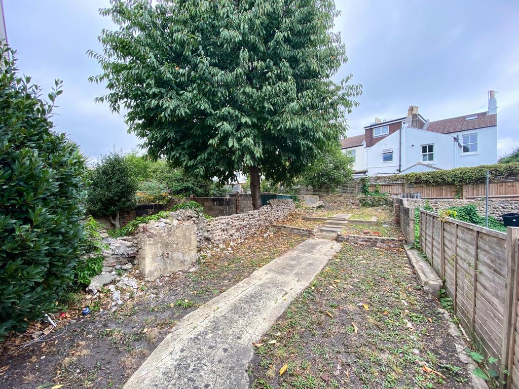 Well‑kept rear garden with a central paved path...