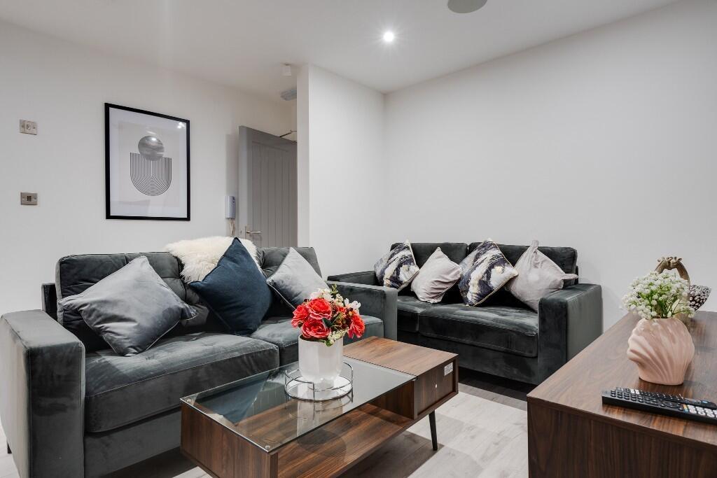A modern, well-lit living room featuring comfor...