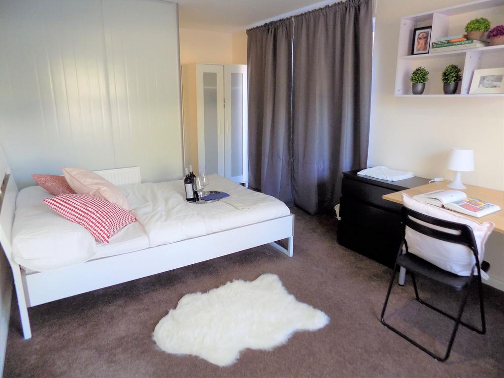 Bright, neatly styled bedroom with a white doub...