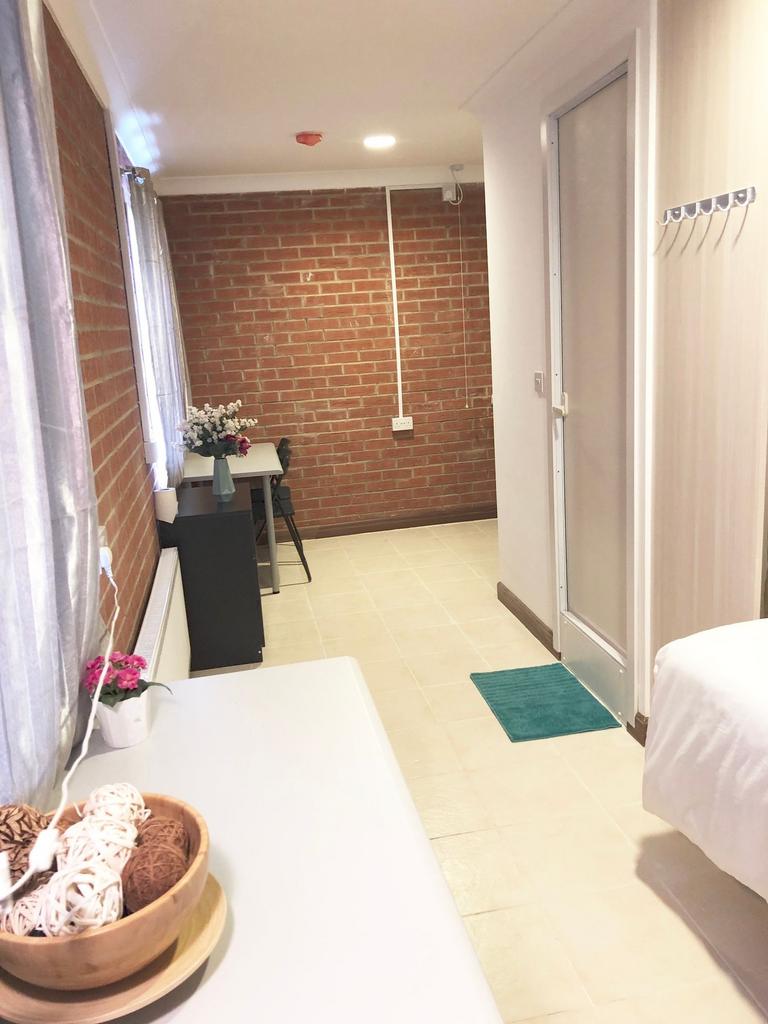 Bright, tidy single bedroom with a neutral tile...