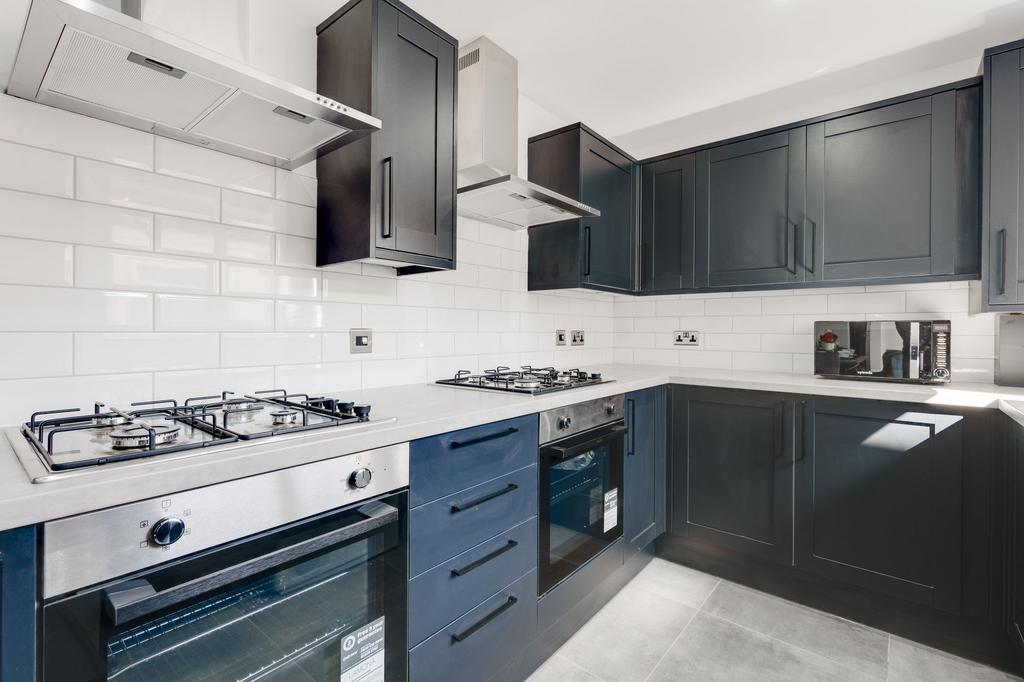 Modern fitted kitchen with dark cabinetry, whit...