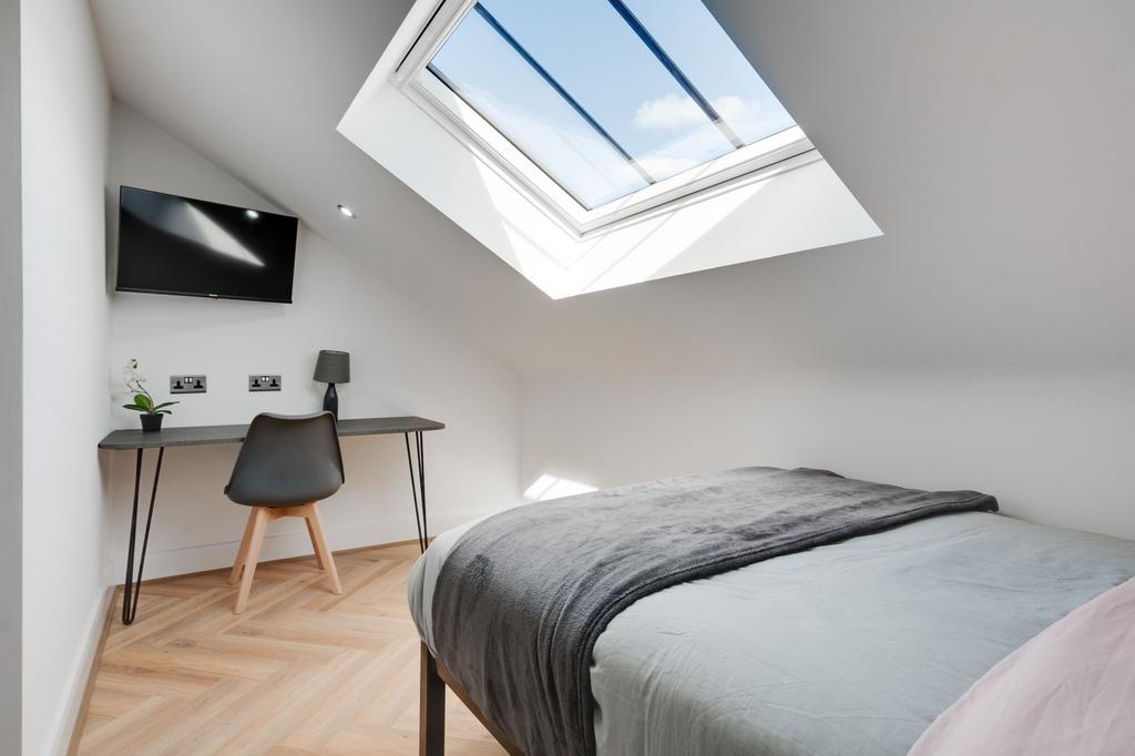 Bright, modern master bedroom featuring a cozy ...