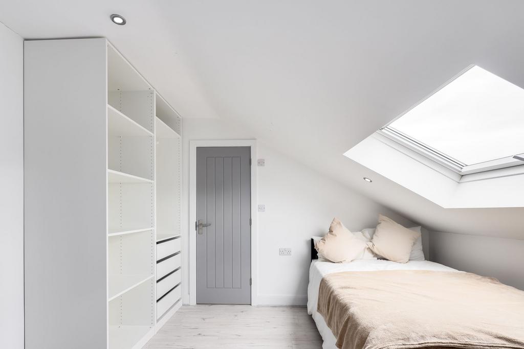 Bright and spacious bedroom featuring a large b...