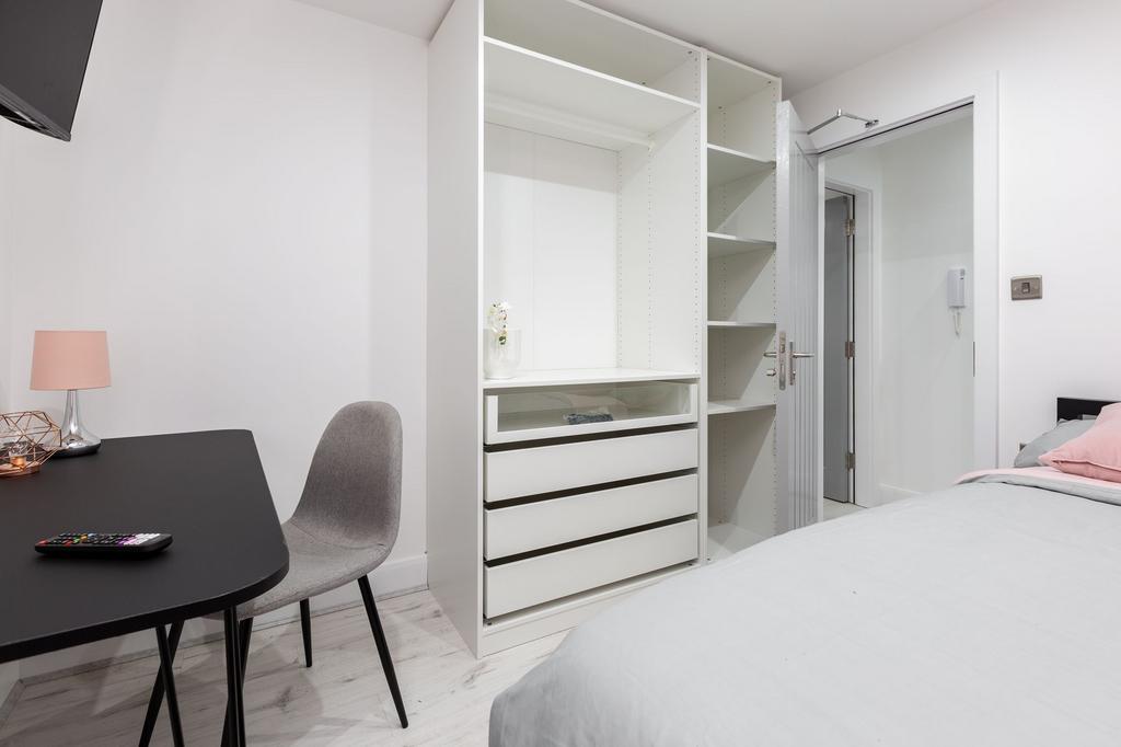 A modern, bright bedroom with a neatly arranged...