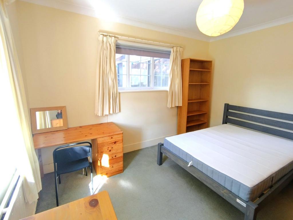 Bright, simply furnished bedroom with a double ...