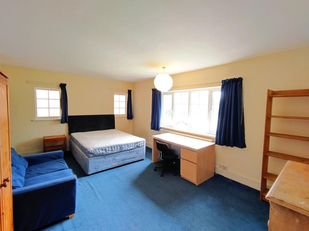 Bright, spacious bedroom with a large window le...