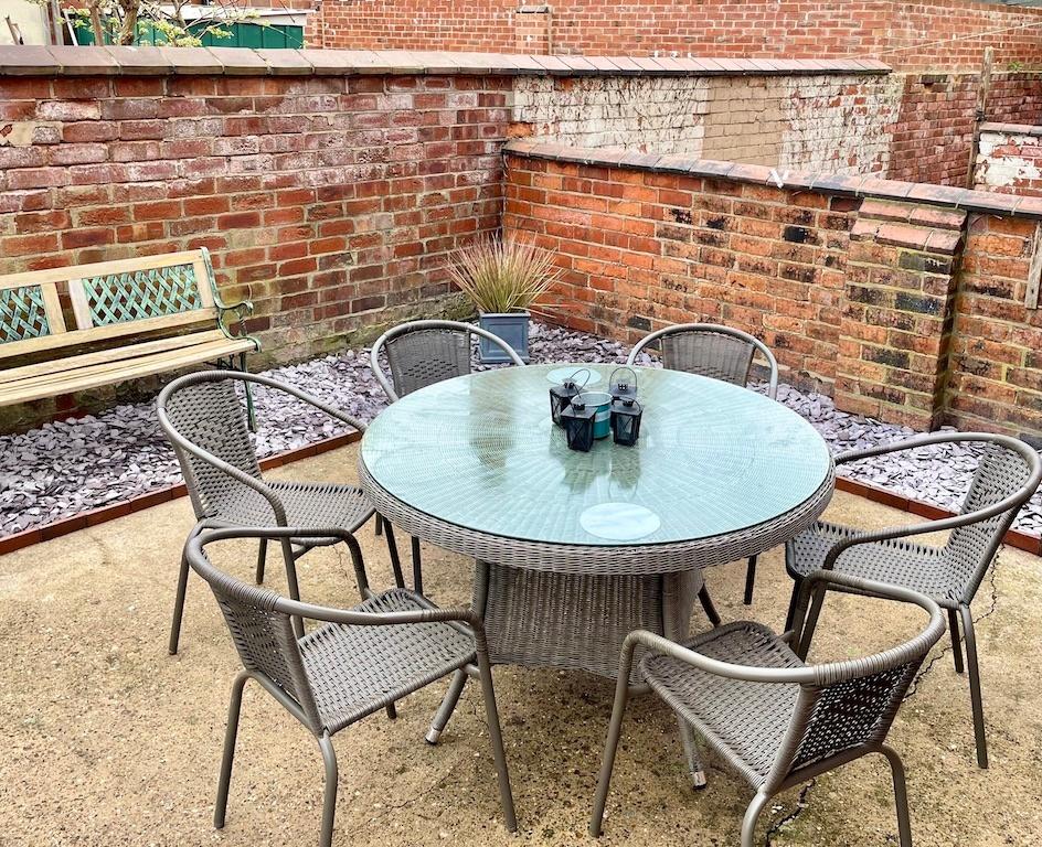 Private paved courtyard with a round glass-top ...