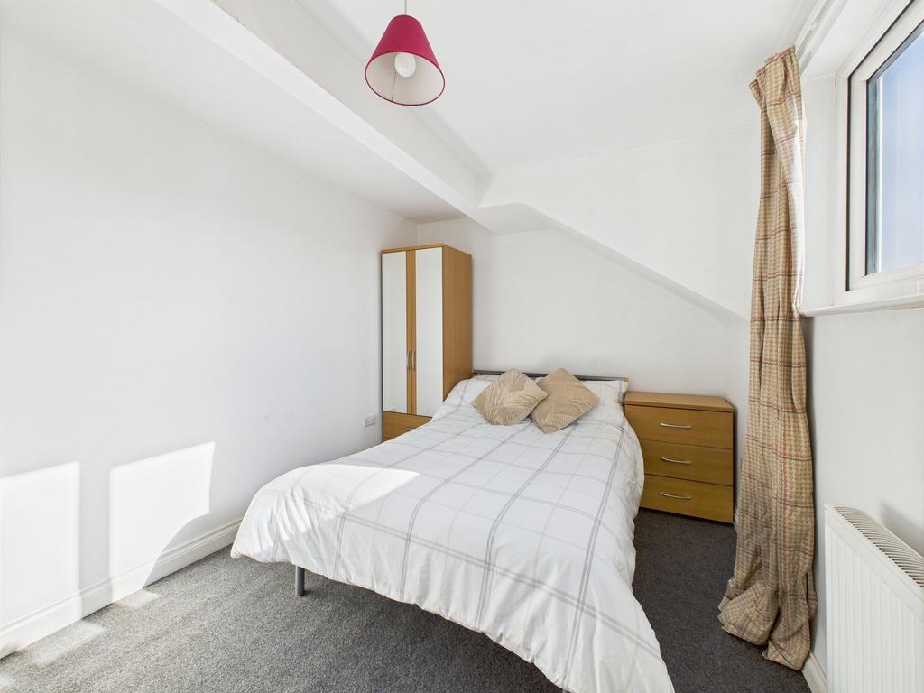 A well-lit, tidy double bedroom featuring a com...
